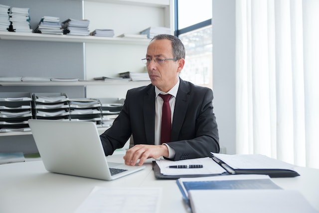 property manager at their desk working on their laptop with files organized behind them